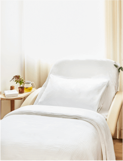 sollis health patient room with bed and side table with sunshine coming through curtains