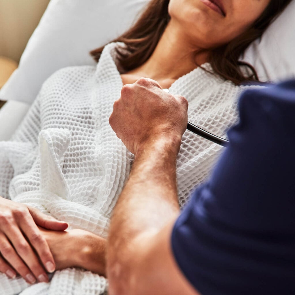sollis employee checking the chest of a patient with stethoscope