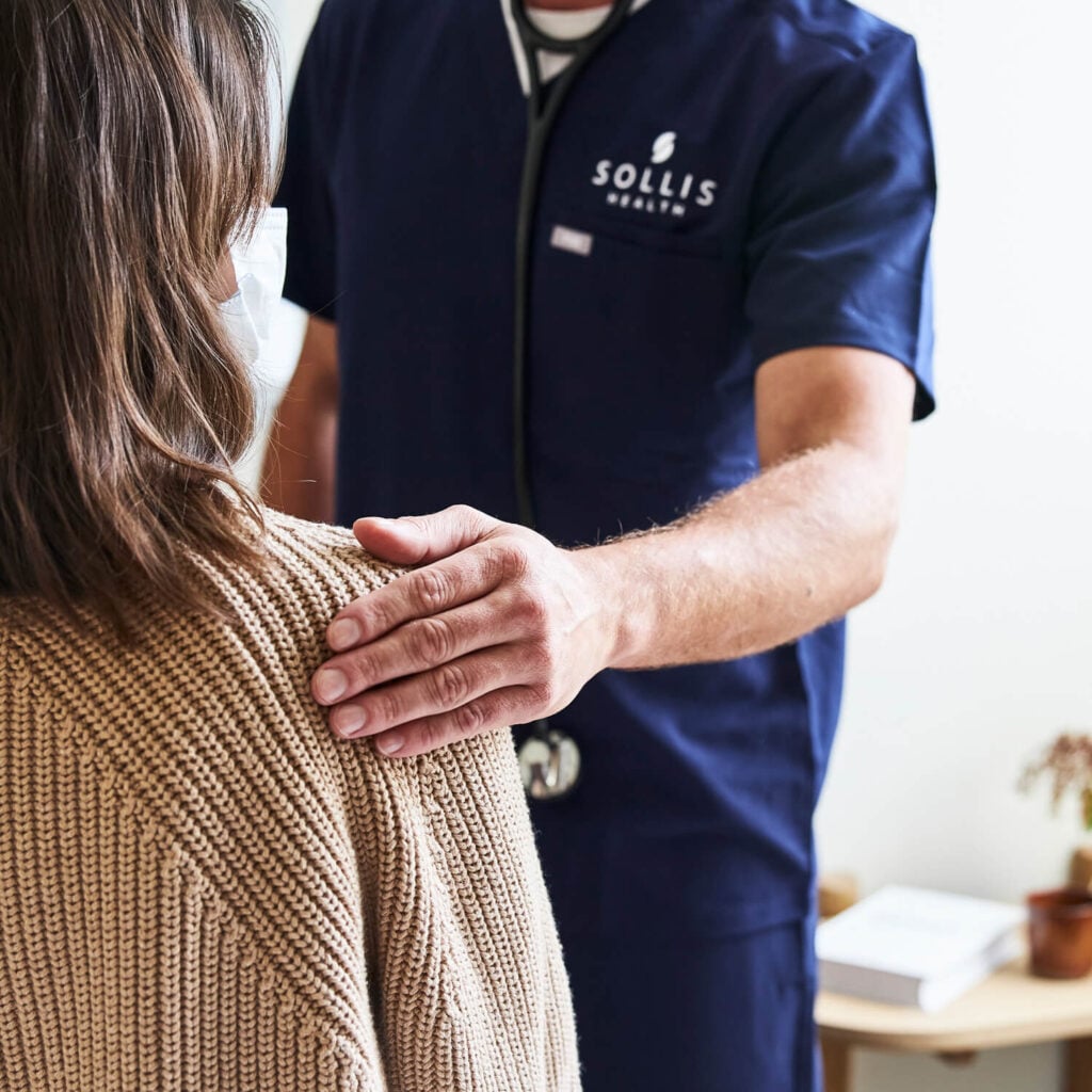 sollis doctor resting hand on the shoulder of a patient