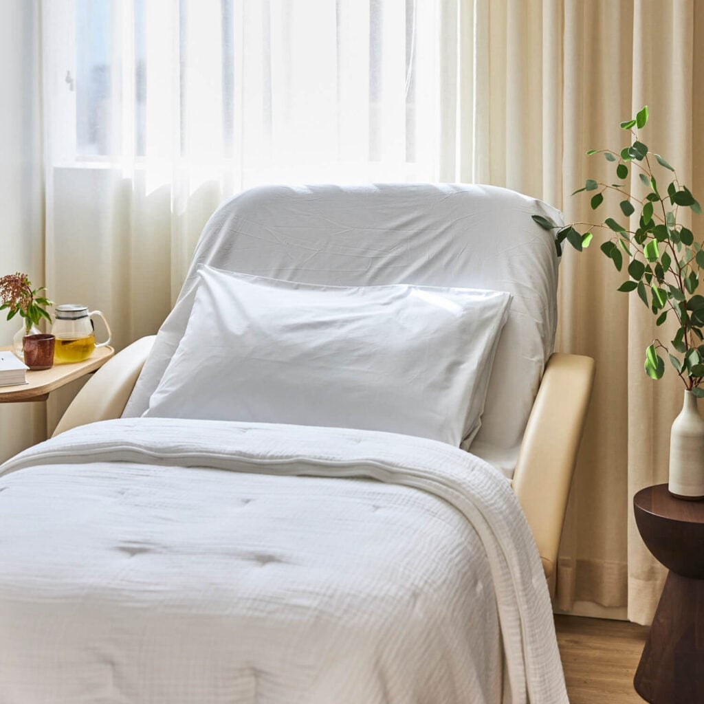sollis patient care room with bed, side tables, and sunshine coming through curtains